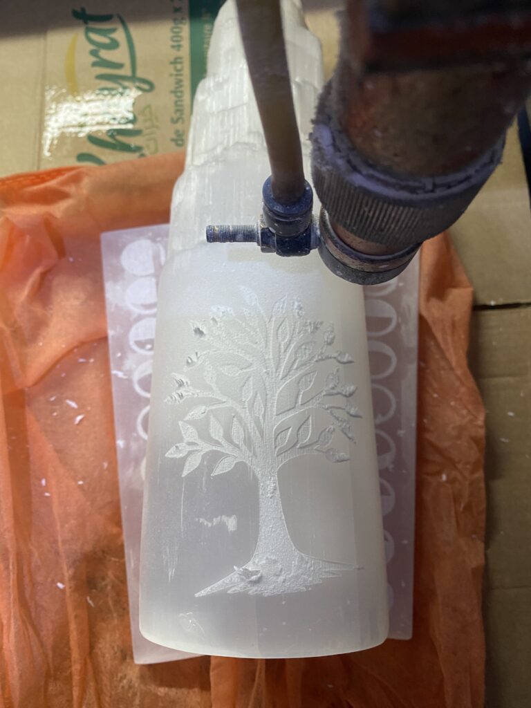 How We Travel the World to Source Our Crystals - Morocco 2024 12 Close up of hand engraving detail work on a selenite lamp in Morocco