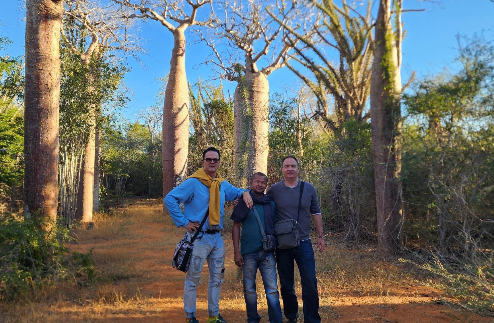 How We Travel the World to Source Our Crystals – Madagascar 2026 5 Co-founder Patrik, tour guide Rene, and Paul before the majestic Baobab Forest in Madagascar