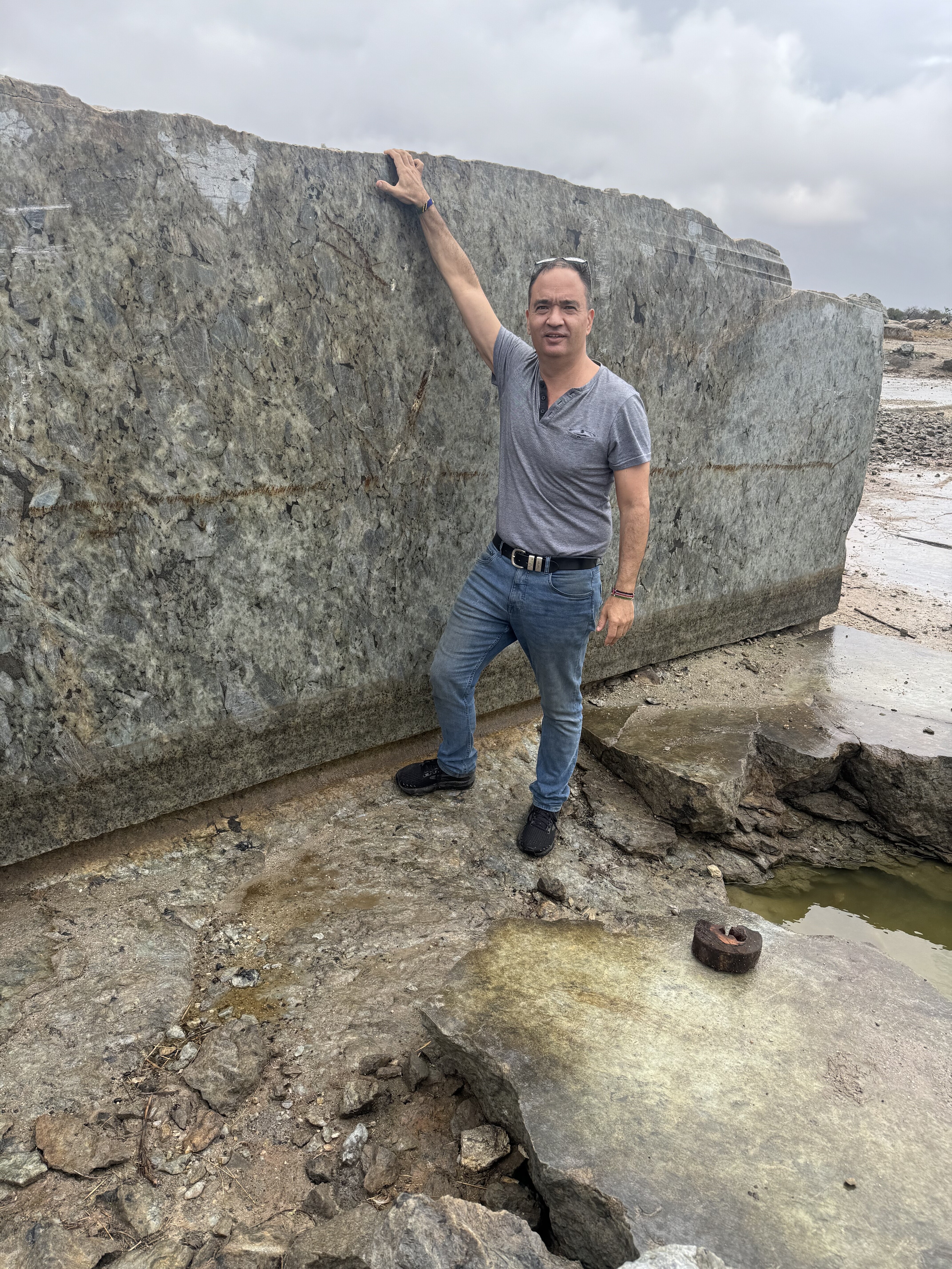 How We Travel the World to Source Our Crystals – Madagascar 2026 8 Patrik standing with a massive raw-sawn labradorite slab at the labradorite mine in Madagascar